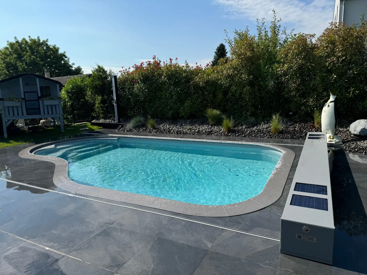 Piscine Waterair forme haricot, terrasse en ardoise