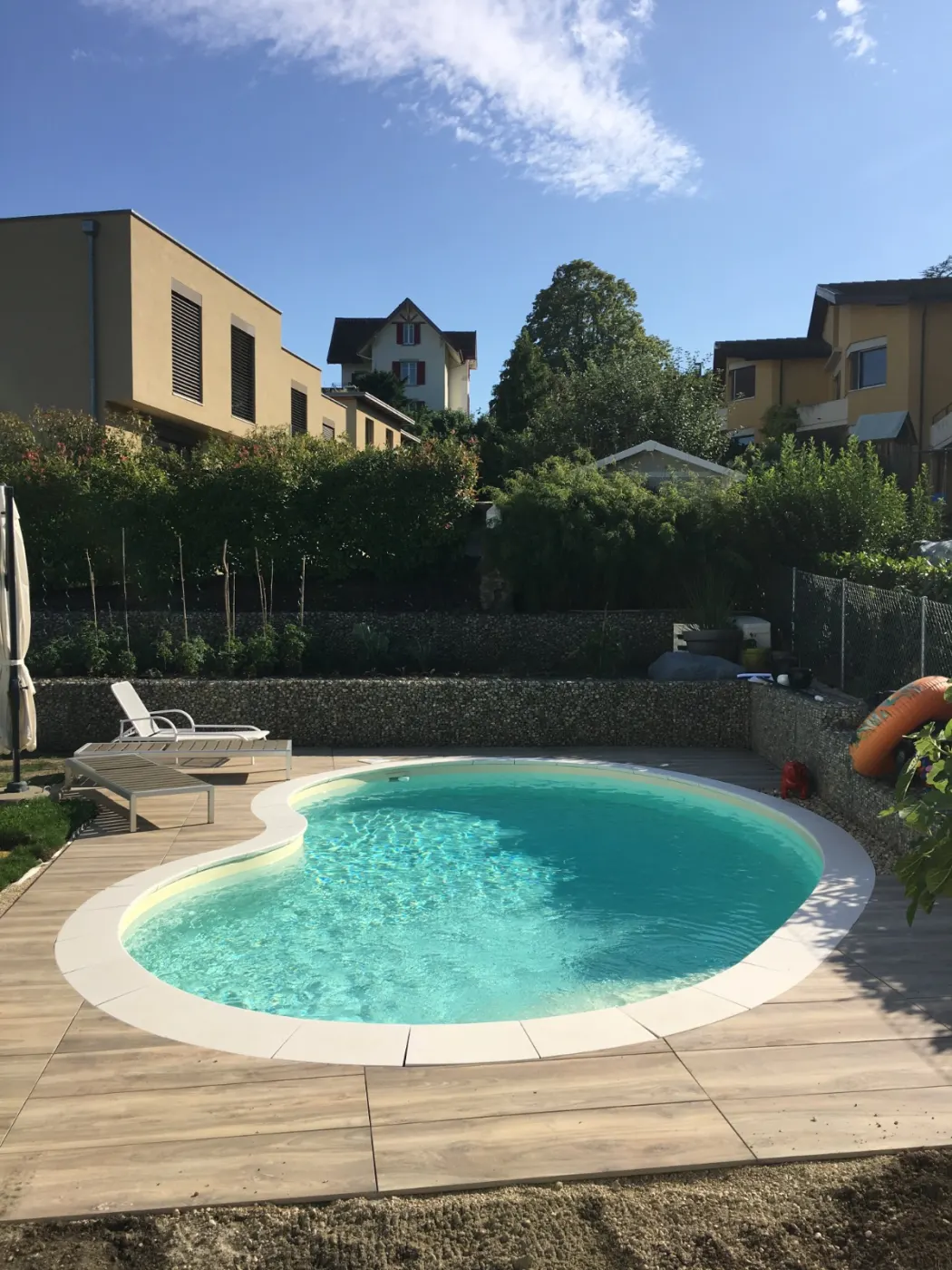 Piscine Waterair forme haricot, terrasse en bois